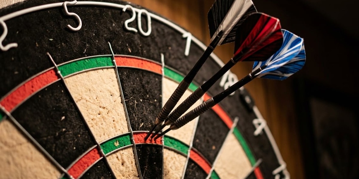 Three darts lodged in the twenty segment of a dartboard under warm light, against a dark wood-panelled wall